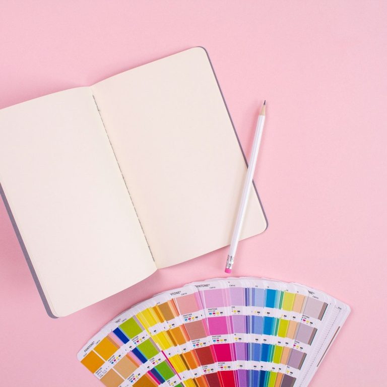 teintes de postures Carnet vierge ouvert avec un crayon et un nuancier en bas.