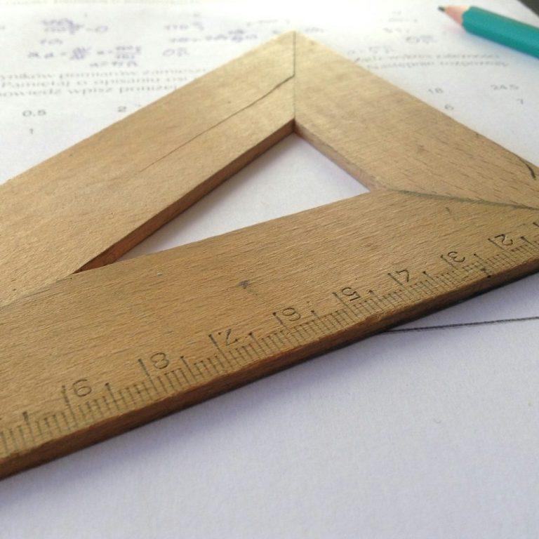 ingénierie Équerre en bois sur un fond de papier avec des annotations et un crayon.