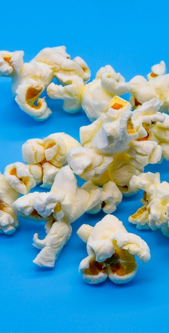 pop corn Popcorn éparpillé sur un fond bleu.